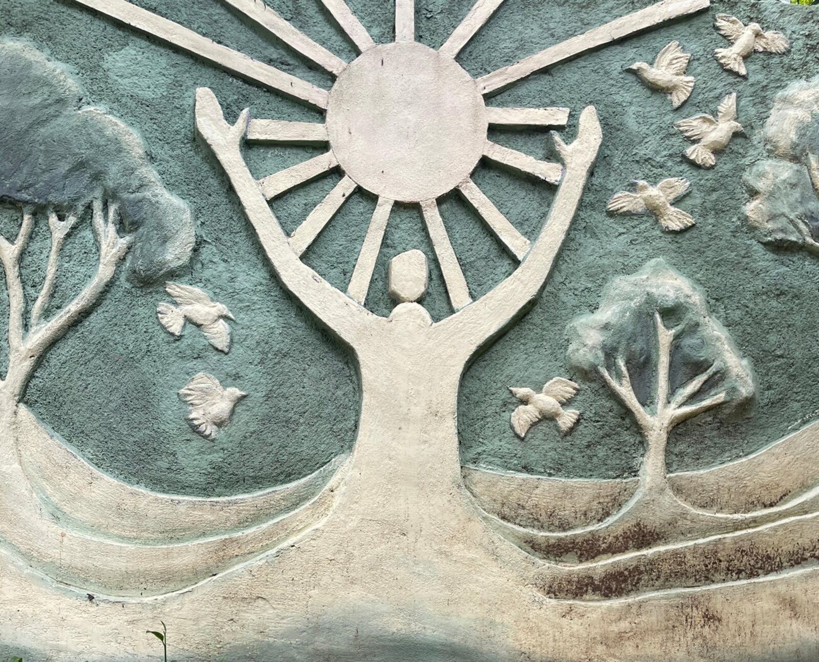 Sculpture at Punarjjany depicting a figure releasing birds toward the sun, symbolising rebirth and recovery