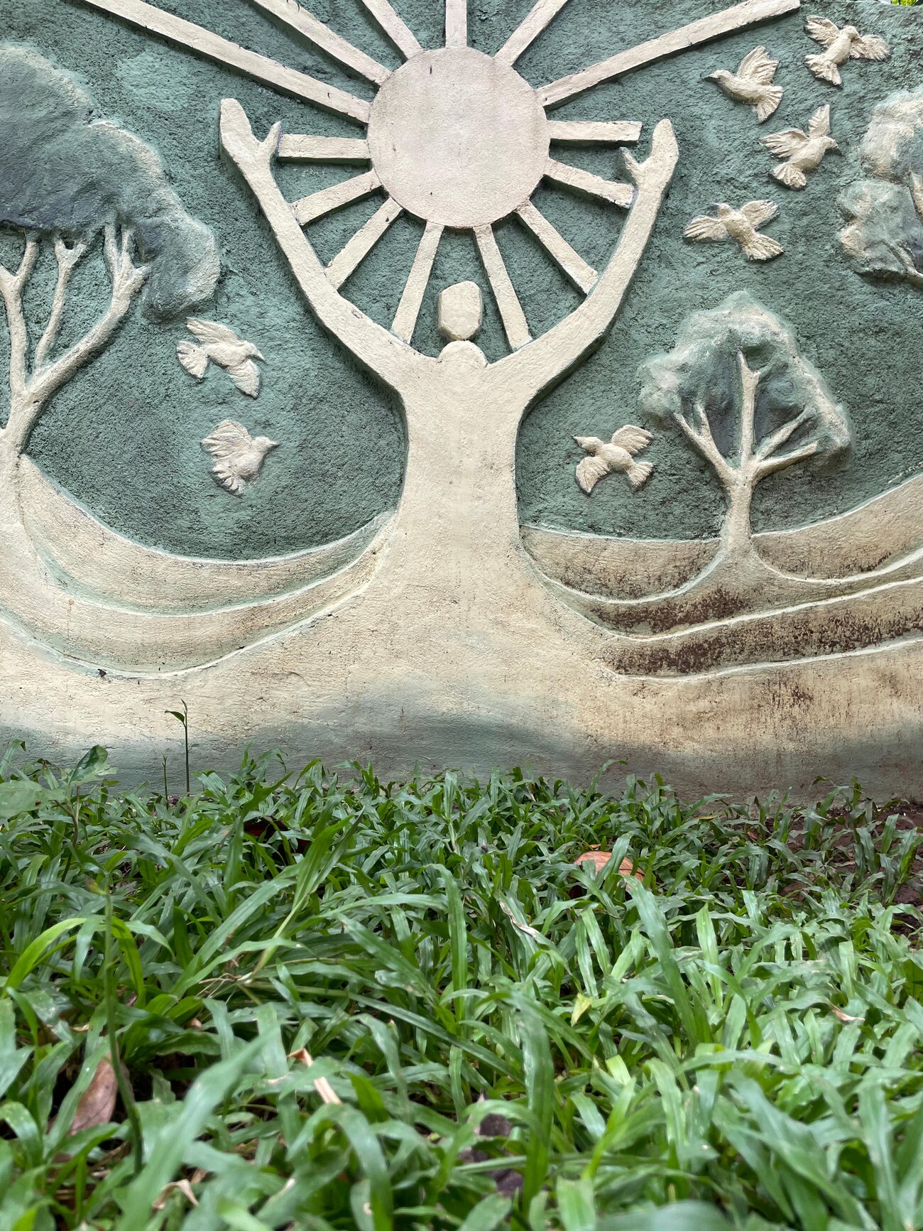 Sculpture at Punarjjany depicting a figure releasing birds toward the sun, symbolising rebirth and recovery
